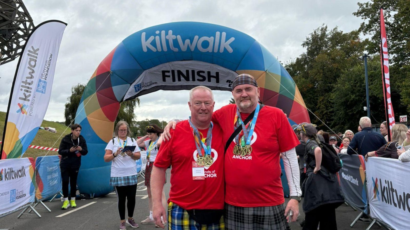 Scott and Mark at the finish line of final Kiltwalk with all 4 medals