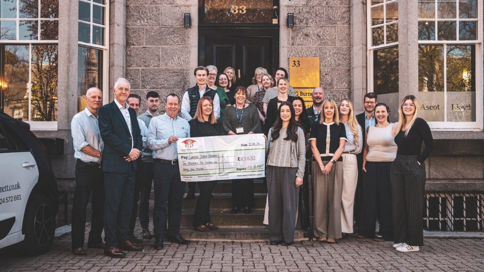 FG Burnett Managing Director, Graeme Nisbet, presenting a cheque to Kate Mackenzie, Executive Assistant at Camphill School Aberdeen, joined by members of the FG Burnett team.