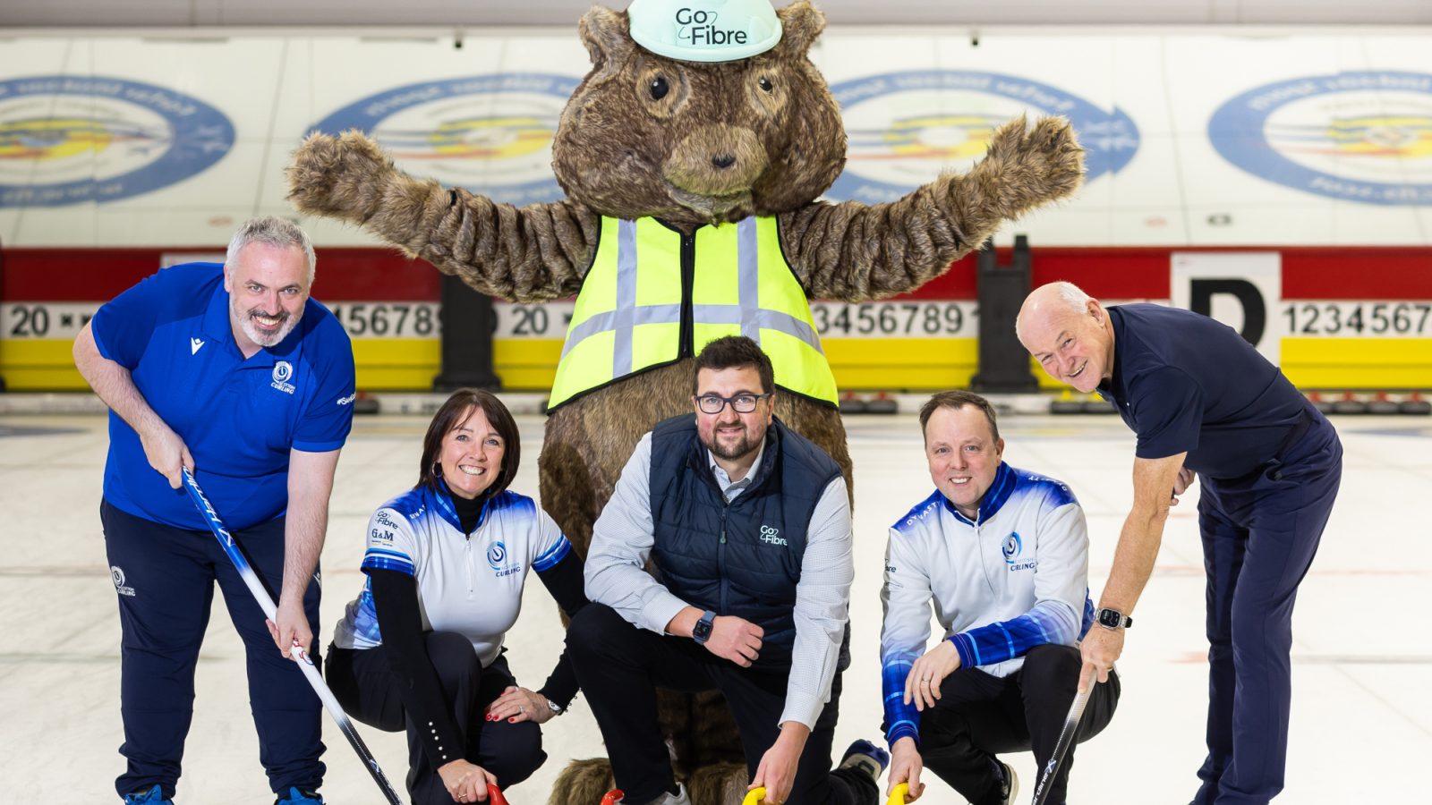 From left to right: Vincent Bryson, CEO, Scottish Curling; Jackie Lockart, Scottish Senior Women’s Skip; John Paterson, Senior Contract Manager, GoFibre; Tom Brewster, Scottish Senior Men's Skip; and Mike Ferguson, Managing Director/Sports Manager, Forfar Indoor Sports; with GoFibre's mascot, Digby, at Curl Forfar.