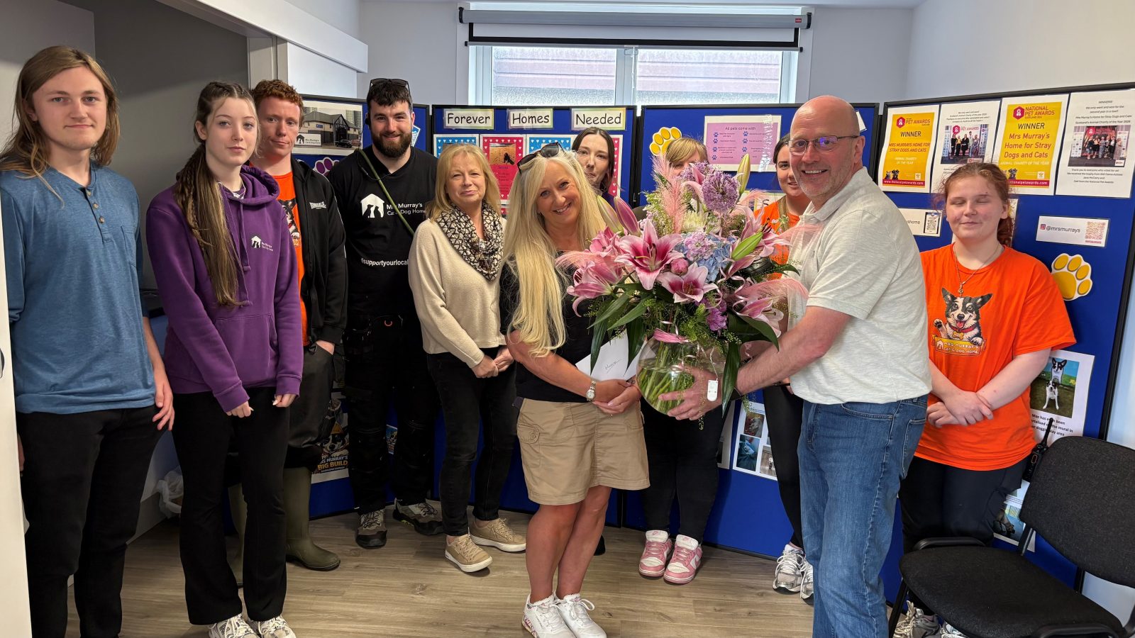 Marie Simpson being presented with flowers for her 40 years of service by Chairman Alan Grant, surrounded by some of the wider team.