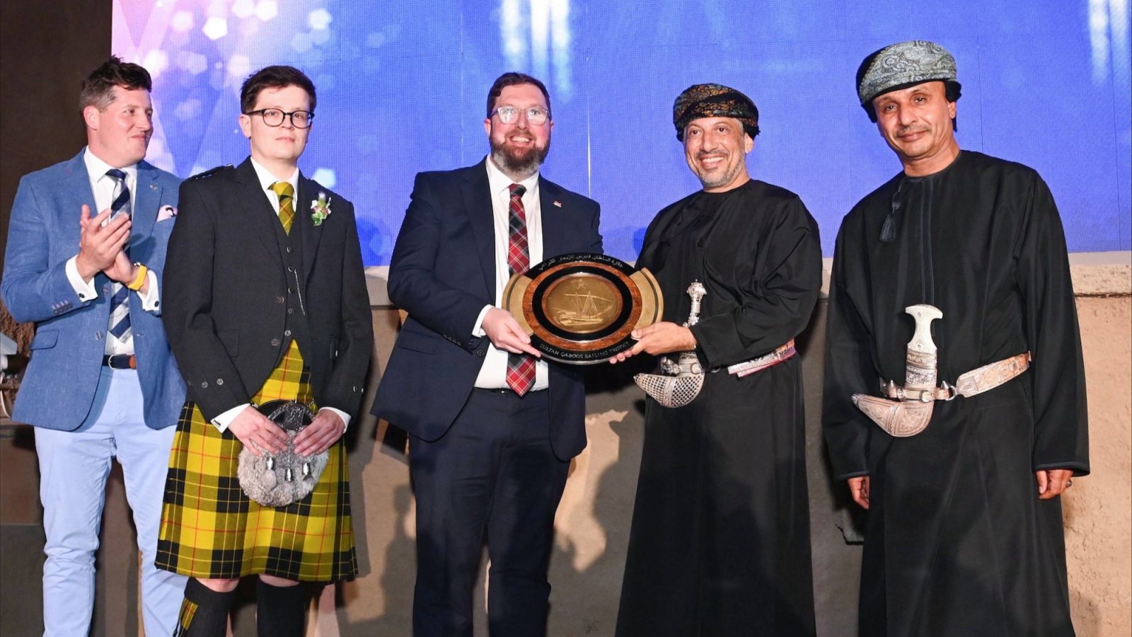 From left, James George, Chair of Trustees, Sail Training International; Blair MacAskill, Aberdeen youth sail trainee; Matthew Williams, Tall Ships Officer, Aberdeen City Council; His Highness Sayyid Harib Bin Thuwaini Al Said; and Commander of the Royal Navy of Oman, Rear Admiral Saif Nasser Al Rahbi. Image courtesy of the Royal Navy of Oman